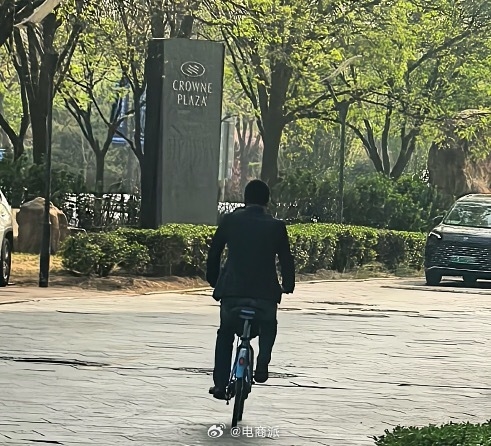 蔚来CEO李斌骑共享单车赶车展 街头大方和路人合影